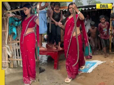 Viral video: Woman in saree shows off giant snake wrapped around her body, watch